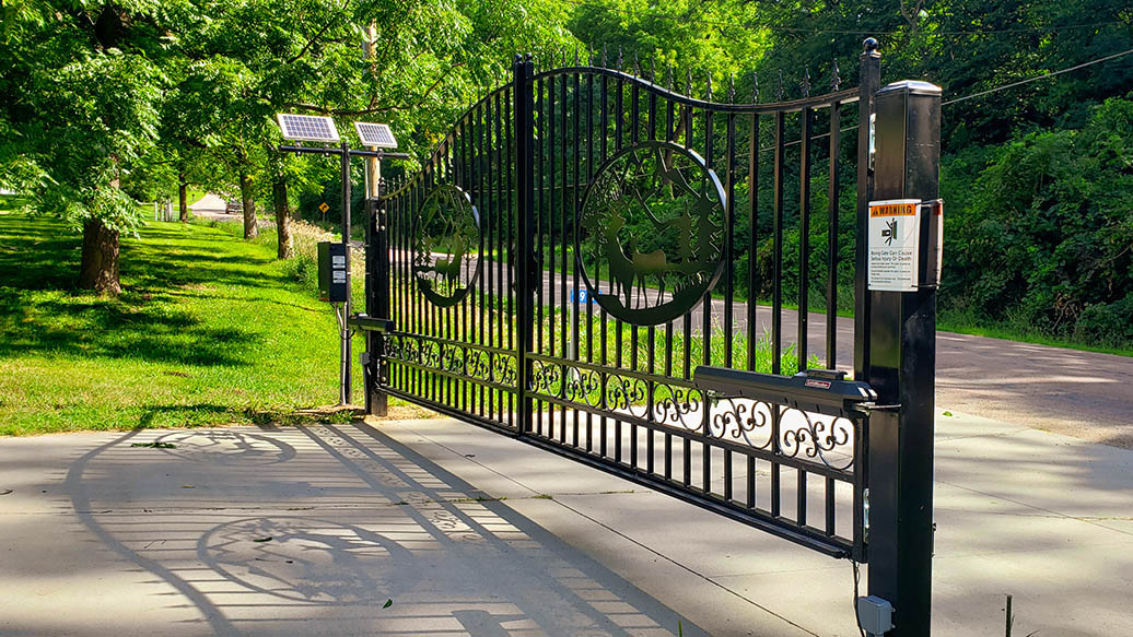 Custom ornamental automated double swing gate with solar-powered operator arms